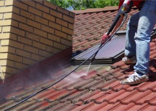 Mężczyzna czyści dachówkę karcherem